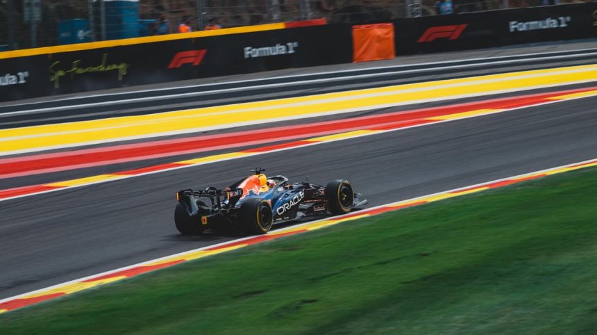 Carro de Fórmula 1 em alta velocidade no circuito de Spa-Francorchamps, na Bélgica, durante um dia ensolarado de corrida.
